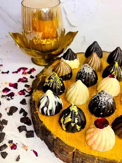 An assortment of our divine chocolate-covered modaks. Each one is beautifully decorated, combining the traditional modak shape with the rich indulgence of gourmet chocolate.
