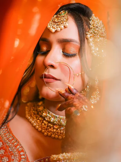 A portrait taken through the orange veil, creating a beautiful color wash and focusing on the bride's profile.