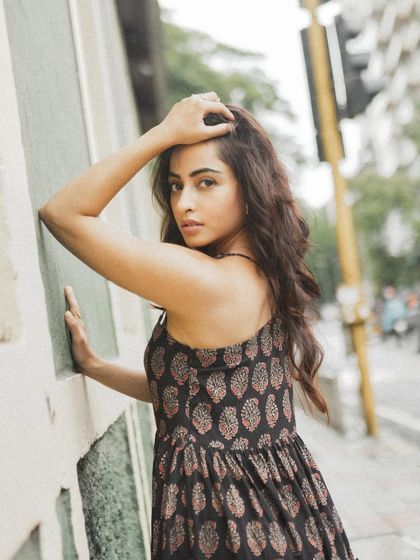 A close-up street portrait, using the texture of the wall and the natural city light to frame the subject.