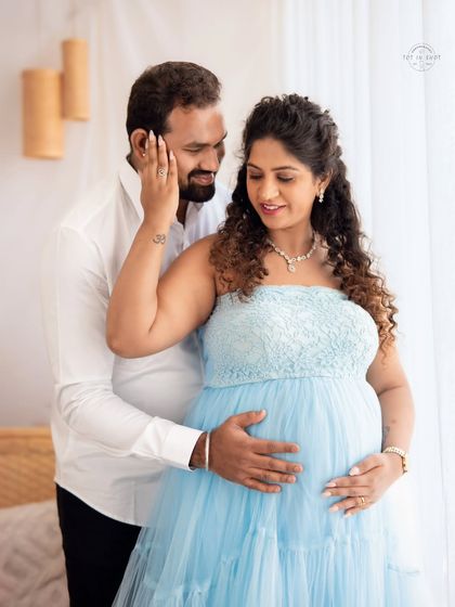 A tender moment captured between a couple, their hands gently resting on the baby bump, filled with love and anticipation.
