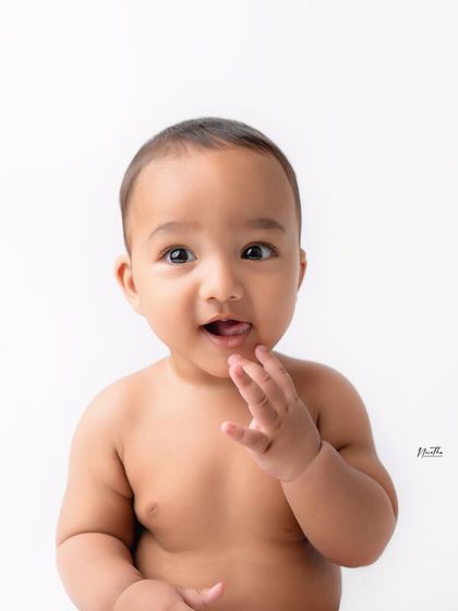 An adorable baby portrait against a clean white background. This minimalist style is perfect for focusing on your baby's cute expressions.
