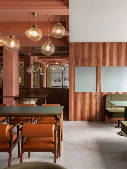 The space is layered with details, from the fluted wood paneling to the custom leather chairs and the mix of modern and traditional lighting fixtures.