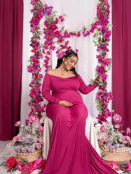Seated amongst a garden of flowers, this mom-to-be looks like a goddess of spring in this colorful studio setup.