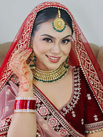 The quintessential Indian bride. I created this classic look with a focus on radiant skin, a timeless red lip, and defined eyes to complement her beautiful smile and traditional red and gold bridal attire.