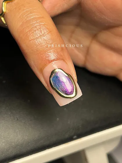 A macro shot of the purple and pink gemstone nail. You can really see the depth of the colors and the texture of the gold chrome frame.