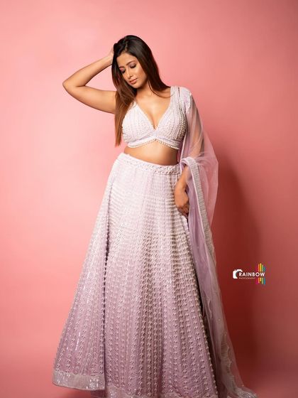 A full-length shot of a beautiful lavender lehenga against a pink studio background. This shows my ability to work with color and create a cohesive, glamorous look.