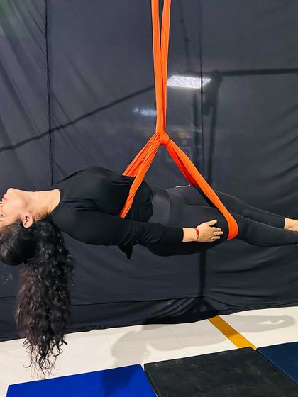 This plank-like pose in the hammock is a fantastic core workout, requiring stability and strength to hold the body parallel to the ground.