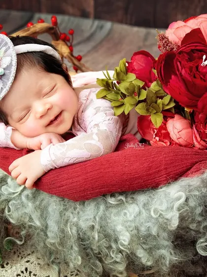 I love how the warm lighting and rich floral props complement her sweet expression. Every detail is planned to create a beautiful and cohesive portrait.