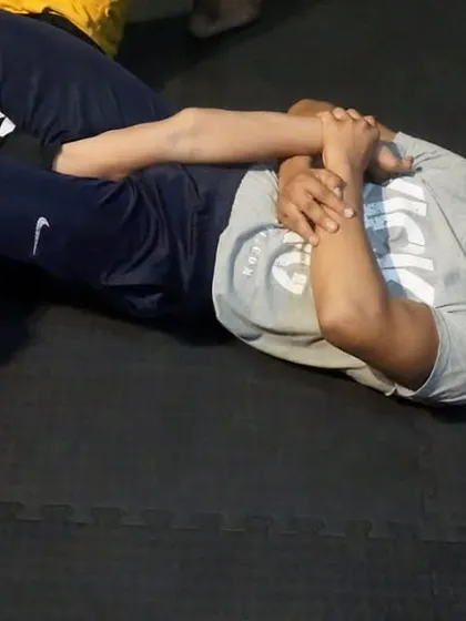 This is a ground survival drill. The student on the bottom is learning to control the opponent's posture and create space to escape or counter-attack. Fights often end up on the ground, and you must be prepared for it.