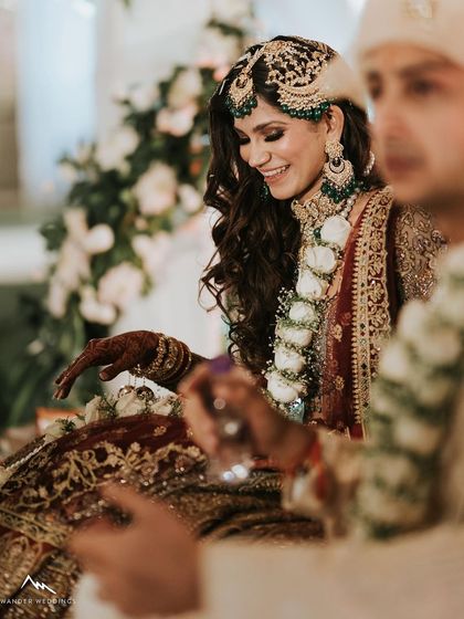 A happy, candid moment during the wedding rituals. Her smile and glowing makeup light up the photo.
