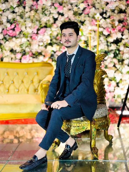 A portrait of the same client seated on an ornate chair. The grooming helps him look poised and ready for the grand celebration.