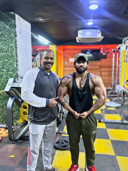 Standing with my coach, my support system. His knowledge has been invaluable, and I pass on these lessons in bodybuilding and life to everyone I train.