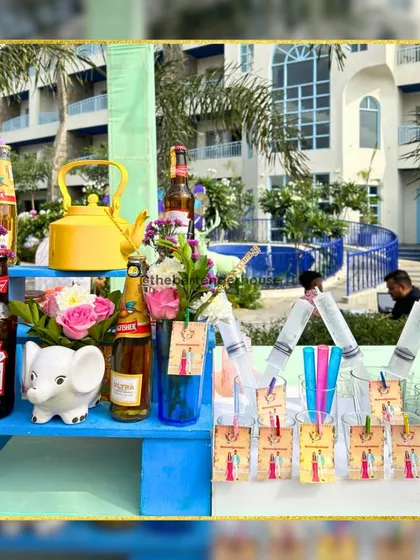 A minimalist bar setup with a pop of color. The blue wooden stand, elephant statue, and syringe shots added a playful and quirky touch to the decor.