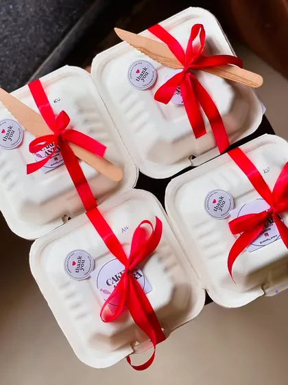 My bento cakes are perfect for gifting, whether it's for one person or a whole group. Here you can see a batch of individually packaged bento boxes, each tied with a bright red ribbon and a wooden knife, ready to be sent out as corporate gifts or party favors.