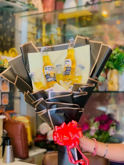 Here’s a fun and quirky option for beer lovers. This bouquet features several bottles of Corona beer, expertly arranged in a bold, black paper wrapping with a bright red bow, making it a guaranteed hit for parties and casual celebrations.