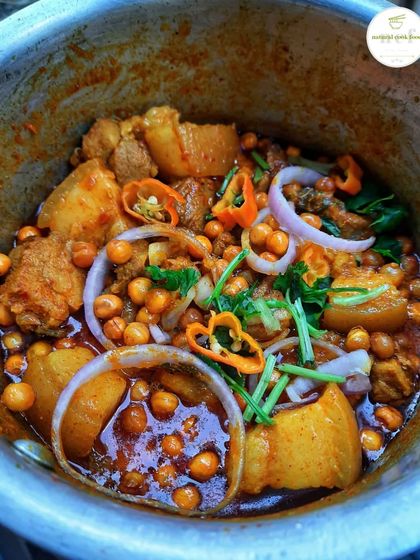 My NCF pork mixture, a hearty and flavorful dish with tender pork, potatoes, and peas, garnished with fresh onion and chillies.