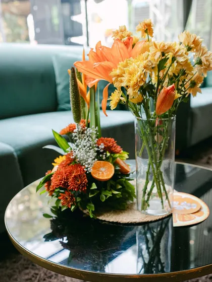 A mix of floral arrangements on a coffee table, combining different heights and textures to create visual interest.