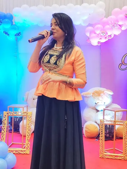 On stage at a 'Boy or Girl' themed baby shower. The decor was adorable, and I had a great time hosting games like the unique Baby Shower Musical Housie for all the guests.