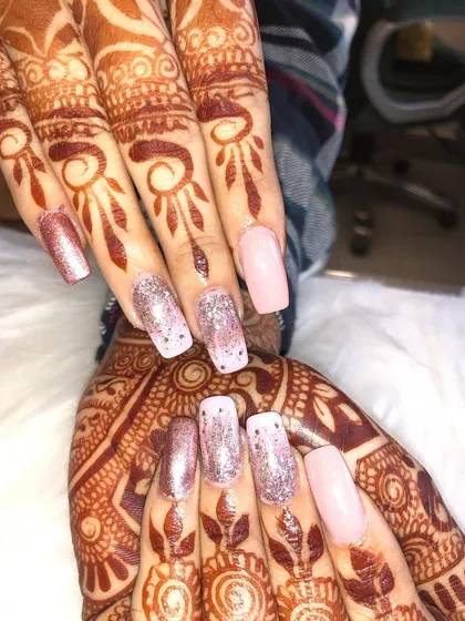 A perfect example of a complete bridal look. Here, I've paired intricate, traditional mehendi covering the full hand with elegant rose gold and glitter nail extensions for a glamorous finish.