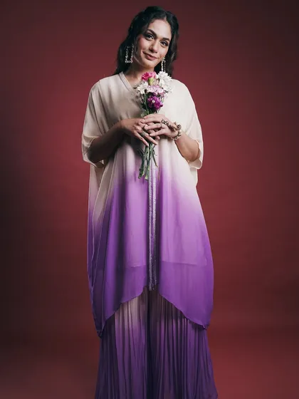 This image is from a designer lookbook shoot, focusing on a clean and elegant presentation. The studio lighting highlights the gentle drape and ombre coloring of the fabric, presenting the outfit in a commercially appealing way.
