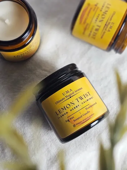 A flat-lay of my 'Lemon Twist' candle. This harmonious blend of citrus and herbs is hand-poured into a classic amber jar, ready to uplift your spirits.
