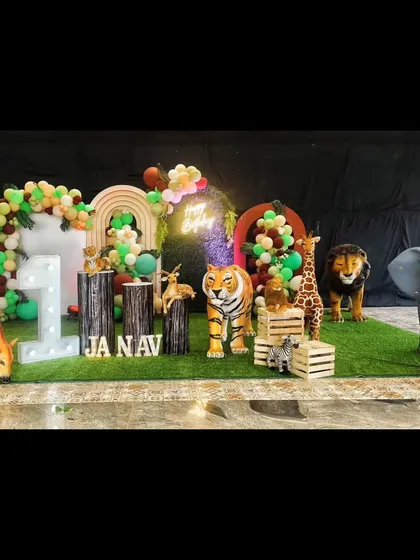 For a truly immersive safari experience, we use large, realistic animal props like this giraffe, elephant, and tiger. Paired with a balloon arch and light-up 'ONE' sign, it creates a spectacular wild animal theme for a first birthday.