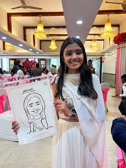 A guest at a party holds her black and white caricature. Even without color, the expressive line work brings out the subject's personality.