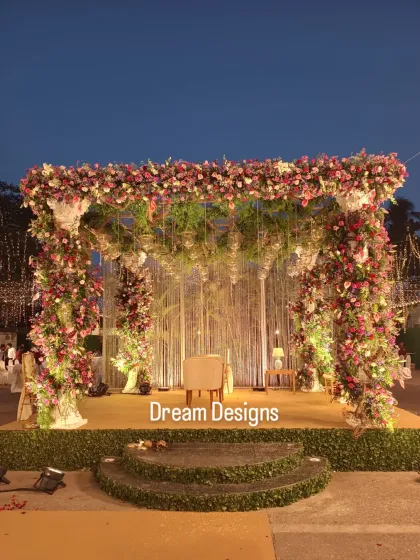 A frontal view of a Parsi wedding mandap, rich with colorful flowers and hanging elements. The design is both traditional and lush, creating a beautiful focal point for the ceremony.