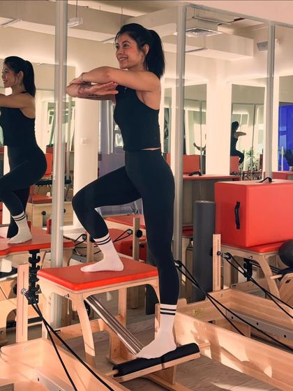 The Pilates chair is a versatile piece of equipment. Here, I use it for a standing step-up exercise that challenges balance, leg strength, and core control.