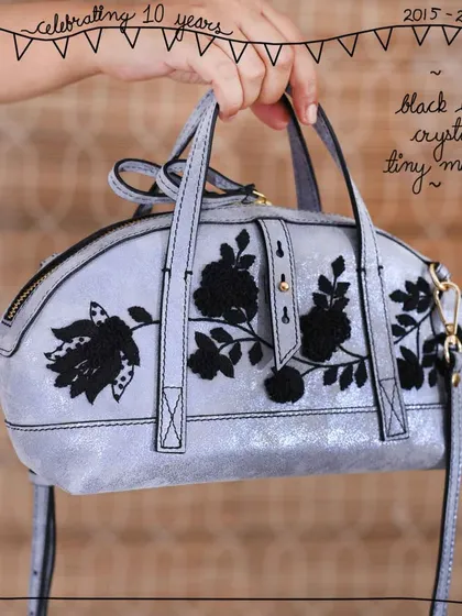The Tiny Mandy bag in our Black Lace Crystal edit. The intricate black floral embroidery creates a dramatic contrast against the shimmering, distressed silver-tone Crystal leather, which is now a sold-out favorite.