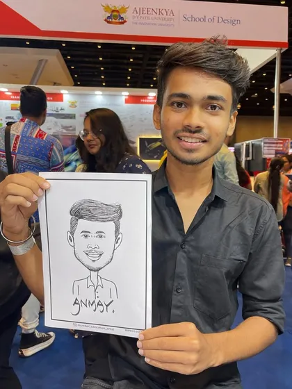 A young man with his caricature at an education fair booth for Ajeenkya DY Patil University. It's an effective way to attract students to your stall.