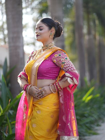 A side view highlighting the detailed embroidery on the blouse and the traditional Maharashtrian ear cuff, known as a 'kaan'.