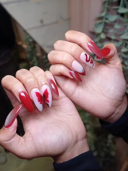 A different pose showing off the sharp stiletto shape and dramatic, hand-painted art of this stunning red set.