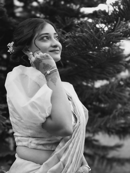 A beautiful black and white portrait of the bride. This classic style highlights her delicate features, elegant hairstyle, and the soft texture of her saree.