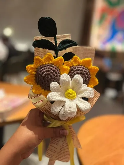 A close-up of this sweet little bouquet, featuring two sunflowers and a daisy. The newspaper wrapping adds a touch of vintage charm.