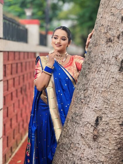 A candid shot of a model in a royal blue Nauvari saree. The makeup is kept subtle to let the vibrant color of the saree stand out.
