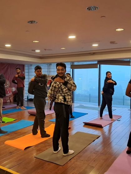 A corporate yoga session focusing on shoulder and neck mobility to release tension from sitting at a desk. Simple movements can make a huge difference.