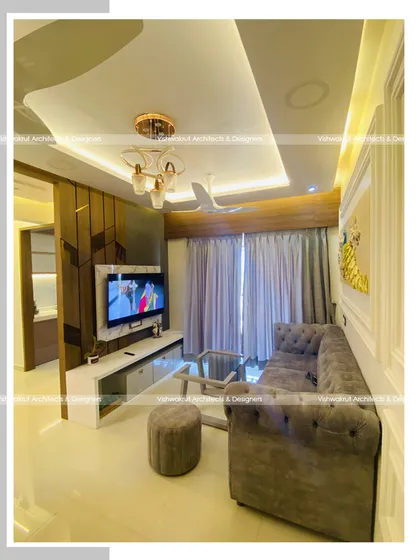 Another angle of the living room in Majestic Villa, Dronagiri. This view shows the TV unit, the false ceiling design with ambient lighting, and the overall color palette that creates a cohesive and modern look.