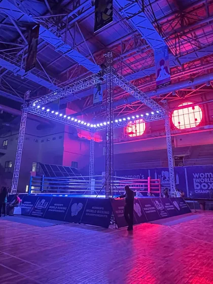 The boxing ring is bathed in dramatic blue and purple lighting. Our state-of-the-art lighting systems can be customized to create any mood or theme for an event.