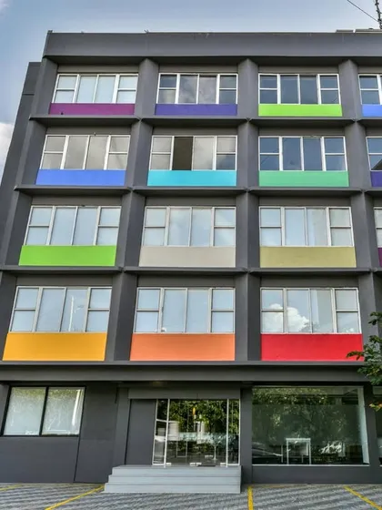 An example of adaptive reuse architecture. We converted a drab, old hotel building into a vibrant co-working space by giving the facade a modern grey finish and adding pops of color.