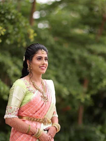 A candid shot of the bride in her pastel saree. The natural makeup and simple braided hairstyle create an effortlessly elegant look for her engagement event.
