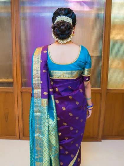 A full back view showing the neatly draped saree and the beautiful gajra adorned bun, a classic and timeless hairstyle.