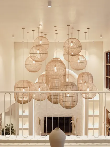 A view from the upper floor looking down at the dramatic chandelier of woven lamps. This perspective highlights the verticality of the space and the interplay of light and shadow, central to my architectural approach.