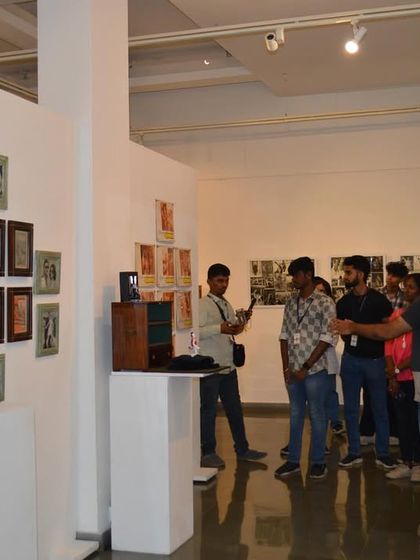 A faculty member photographs his students as they interact with the exhibition, capturing their engagement.
