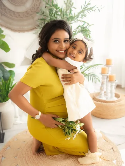 A mother and daughter share a warm embrace. This photo, taken during a maternity session, beautifully captures the existing bond before a new baby arrives.
