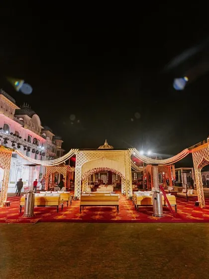 A wide shot of the royal wedding setup at night, with golden-domed canopies and a rich red carpet creating a truly regal ambiance at The Leela Palace.
