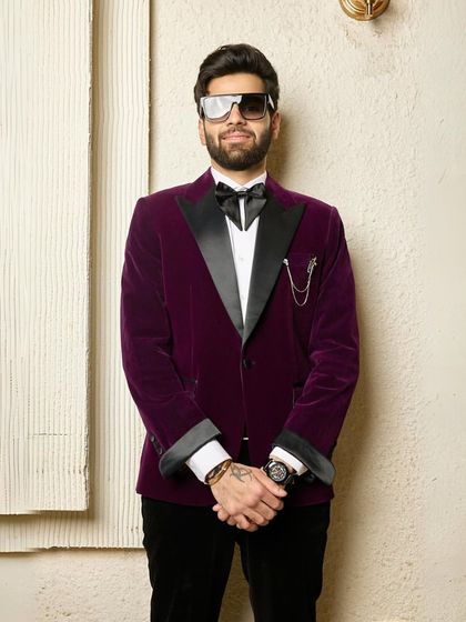 This wine-colored velvet tuxedo is the definition of opulent style. Paired with a statement bow tie and lapel chain, this three-piece suit is crafted for high-profile ceremonies and parties.