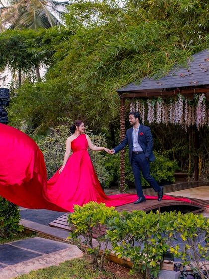 A beautiful shot of a couple on the wooden bridge, with the red dress creating a striking line through the lush green landscape.