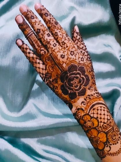 A different floral design with a large central rose and delicate patterns on the wrist.