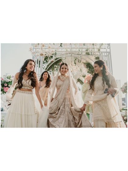 The bride walking with her bridesmaids, sharing a laugh. This candid shot captures the joy and support of her bride tribe on her wedding day.
